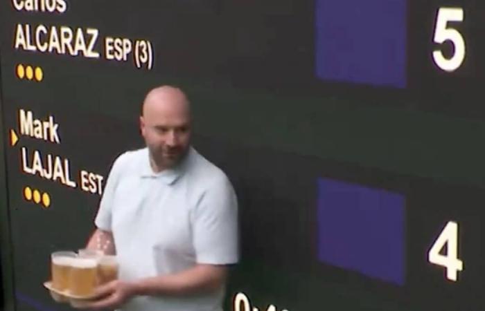 Ein Mann läuft mit einem Tablett Bier verloren im Wimbledon Centre umher: Der Sicherheitsdienst greift ein